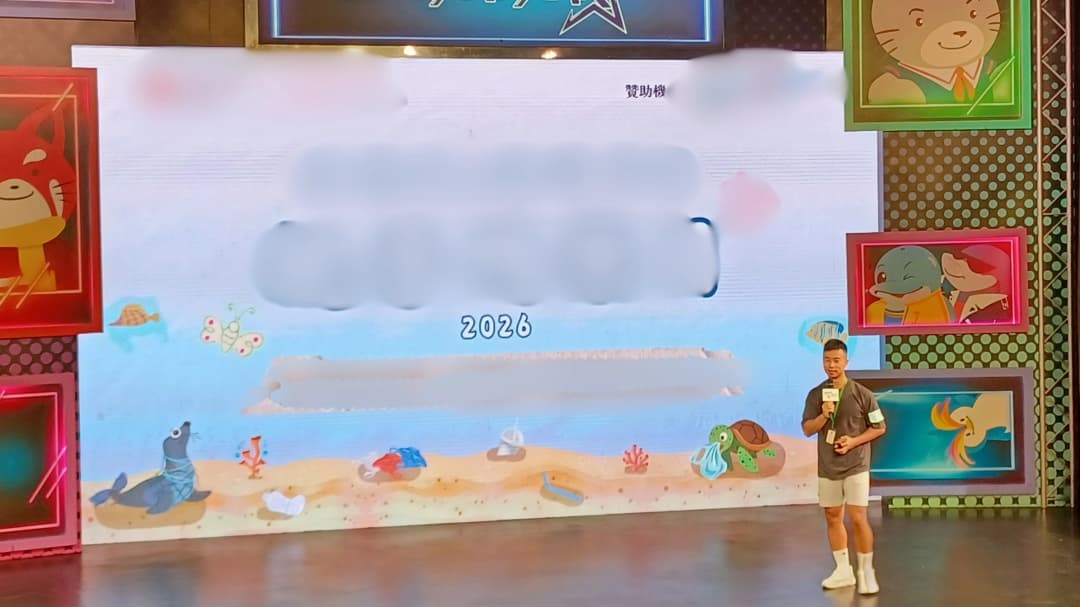 在舞台上手持咪高峰向現場觀眾演講